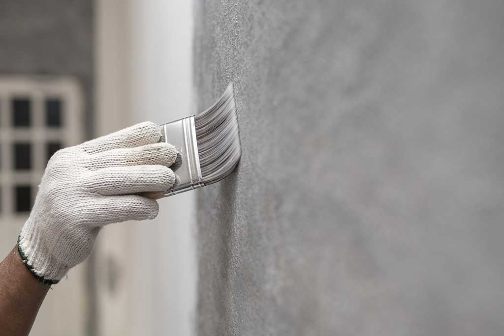 Graffitientfernung mit Pinsel an der Hauswand