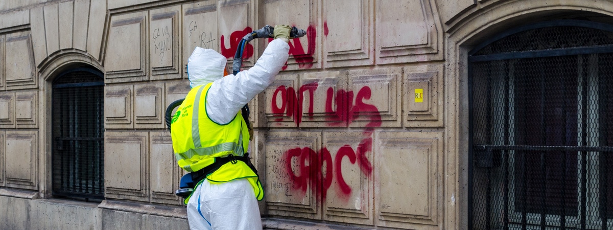 Graffiti wird von einer Hauswand entfernt